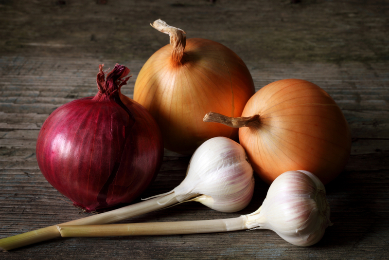 Zwiebeln und Knoblauch in Papiersäcke stecken | Getty Images Photo by Savushkin