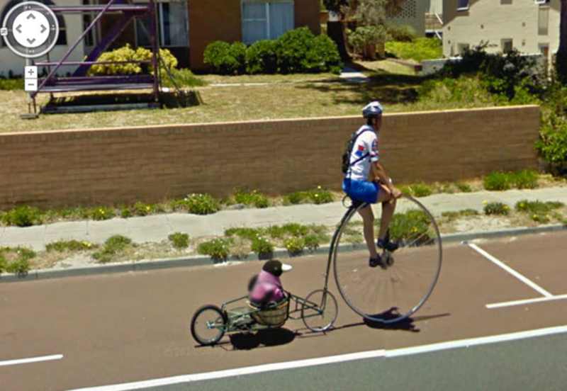 Un hombre en una rueda alta... remolcando un pingüino | Imgur.com/rhH2YrU via Google Street View